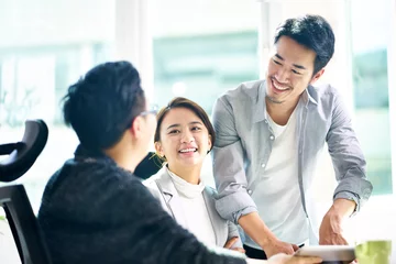Foto op Plexiglas three happy asian teammates discussing business in office © imtmphoto