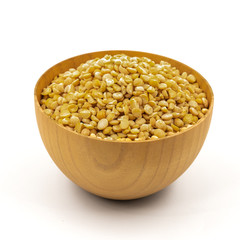 Raw yellow split peas in a wooden plate (bowl) isolated on white background