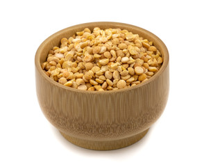 Raw yellow split peas in a wooden plate (bowl) isolated on white background