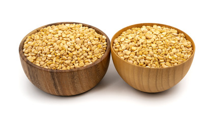 Raw yellow split peas in a wooden plate (bowl) isolated on white background