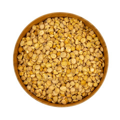 Raw yellow split peas in a wooden plate (bowl) isolated on white background, top down view