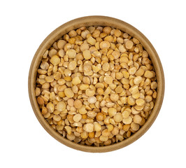 Raw yellow split peas in a wooden plate (bowl) isolated on white background, top down view