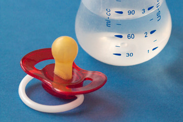 baby nipple with bottle stand on blue background