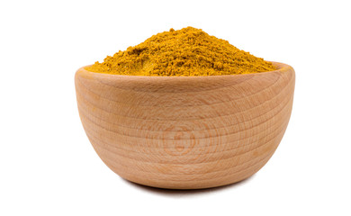 yellow curry in wooden bowl isolated on white background. Spices and food ingredients.