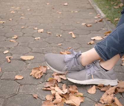Woman feet in sneaker on green grass in the park