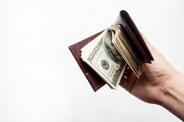 A hand holding a wallet full of one hundred dollar bills isolated over a white background. Copy space