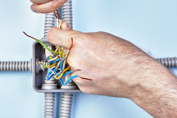 Worker tightens wires by hands.