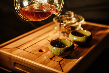 Tea ceremony on the river bank. process of brewing tea in nature using a glass teapot