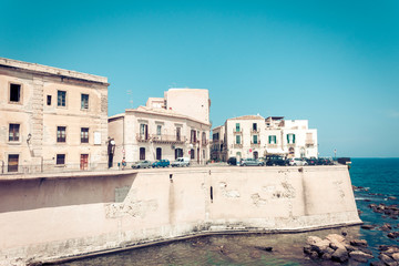 Fototapeta na wymiar Old buildings in seafront of Ortygia (Ortigia) Island, Syracuse, traditional architecture of Sicily, Italy.