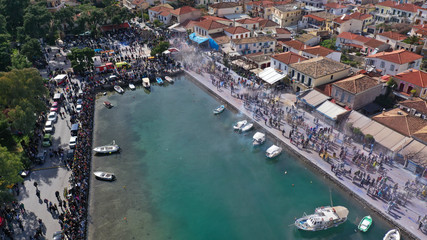 Fototapeta na wymiar Aerial drone bird's eye view photo of people participating in traditional colourful flour war or Alevromoutzouromata part of Carnival festivities in historic port of Galaxidi, Fokida, Greece