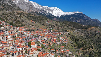 Aerial drone photo from famous and picturesque village of Arachova built on the slope of Parnassus mountain with traditional character at spring, Voiotia, Greece