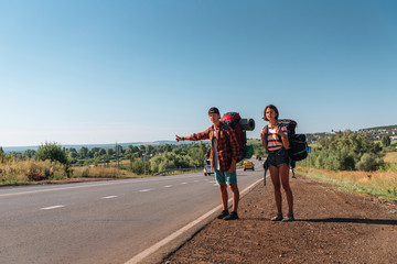 Obraz premium Travel man hitchhiking. Backpacker on road