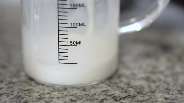 Pouring Milk Into Glass Measuring Cup