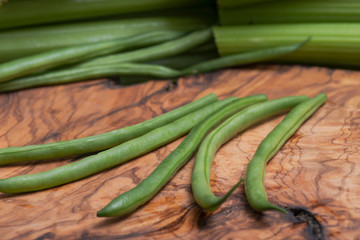Fresh Raw Organic French Green Beans (Haricot Verts), or Filet Beans on natural olive wood.