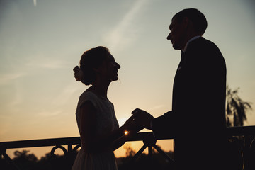 silhouette of a couple sitting on the beach at sunset