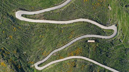 Aerial drone top view photo of serpentine snake curve road in green mountain with beautiful nature