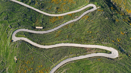 Aerial drone top view photo of serpentine snake curve road in green mountain with beautiful nature