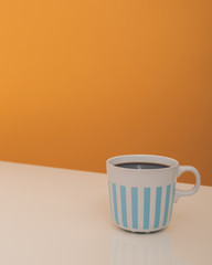 Obraz na płótnie Canvas coffee in white mug with blue stripes