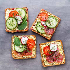 Sandwiches with cream cheese, vegetables and salami.