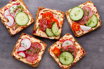 Sandwiches with cream cheese, vegetables and salami.