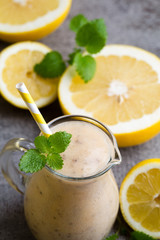 Banana and lemon smoothie, on the grey  background.