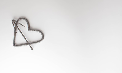Forged heart handmade metal nails on a white background. Forged rose and heart. Flat lay, top view...