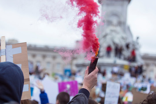 A Protestor Holds A Smoke Bomb At A Political Demonstration