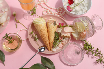 Light pink set of dishes on the table. Delicate rosebuds of pastel colors and petals on a plate and...