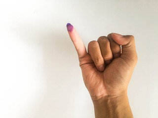Inked pinky finger of a man hand. Purple ink blots from voters finger provides evidence election...