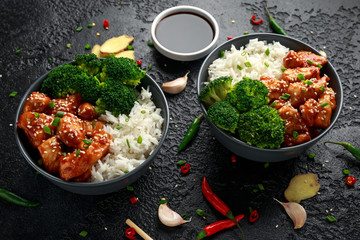 Teriyaki chicken, steamed broccoli and basmati rice served in two Asian clay bowls