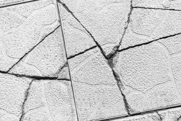 Cracked pavement tiles, gray grunge texture, cracks in the walkway 