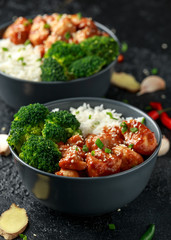 Teriyaki chicken, steamed broccoli and basmati rice served in two Asian clay bowls