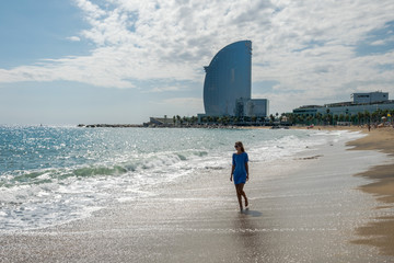 Kobieta idzie po plaży w Barcelonie