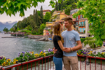Zakochana para spogląda na siebie przy jeziorze we Włoszech - obrazy, fototapety, plakaty