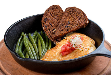 Breakfast in a pan on a white background. Scrambled eggs with asparagus and toast.