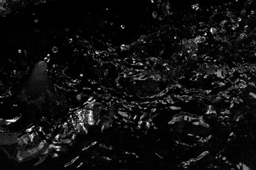 Water splash in dark with a drops of water flying, defocused bokeh 
