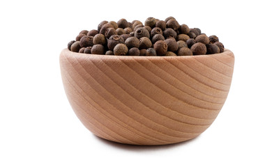 allspice or Jamaican pepper in wooden bowl isolated on white background. Spices and food ingredients.