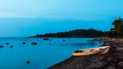 A fishing boat on a sandy beach in sunrise light