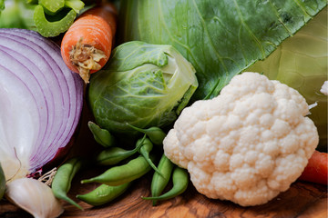 A variety of fresh raw Organic Vegetables including Cabbage, Garlic, Onion, Carrots, Cauliflowers.