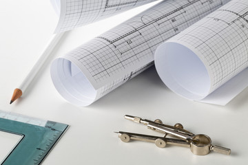 Rolls of architectural blueprint house building plans on white table background