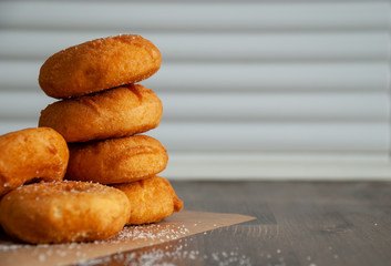 Close-up horizontal of donuts in stack over wood and white wall