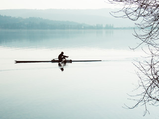 Ruderer auf Boot Langrudern mit Seelandschaft klar Tagsüber mit Wasser und Bergen Radolfzell, Lake...