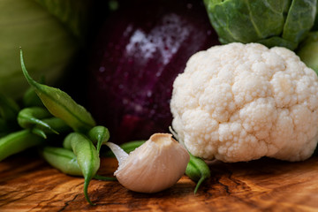 A variety of fresh raw Organic Vegetables including Red Onion, Garlic, French Green Beans, Cauliflower.