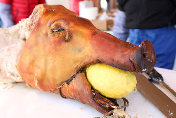 snout of pork cooked with a lemon in the mouth on the festival