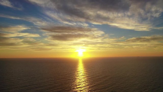 Aerial drone video of beautiful clouds and sunset over Santorini island and the Aegean calm sea