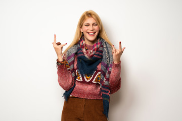 Hippie woman over white wall making rock gesture