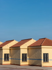 Detalle de unas viviendas adosadas al atardecer bajo un cielo azul
