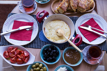 very nicely prepared breakfast table for special, valentines' day or Ramadan or Christmas in the authentic living room. olive,tea,coffee,Muhlama,tomatoes, cheese on the table for party time.