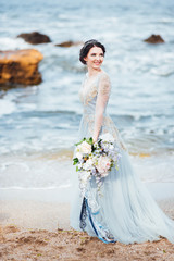 Fototapeta na wymiar bride with a bouquet of flowers on the beach