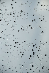Raindrops on window glass Against the background of the spring sky